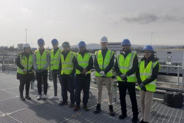 students with hard hats on standing at company premises
